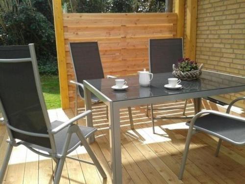 a glass table and chairs on a patio at "Meer" Urlaub in Ostholstein in Oldenburg in Holstein