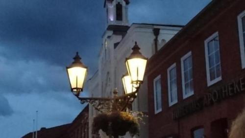 a street light in front of a building with a clock tower at "Meer" Urlaub in Ostholstein in Oldenburg in Holstein