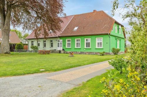 a green house with a red roof on a yard at Ferienwohnung in Kramerhof mit Grill und Garten in Kramerhof