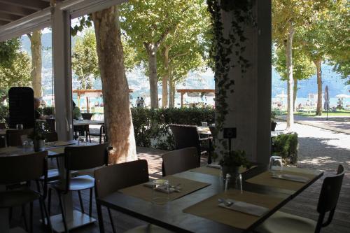 a restaurant with tables and chairs and trees at Camping Del Sole Village in Iseo