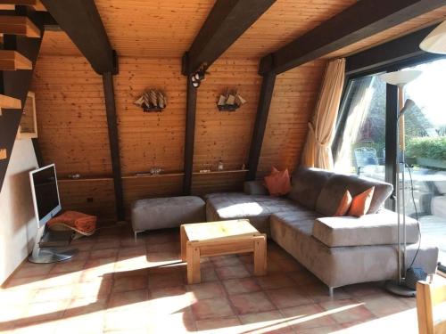 a living room with a couch and a table at Ferienhaus in Fedderwardersiel mit Terrasse in Butjadingen