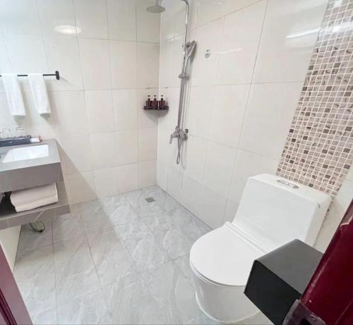 a bathroom with a shower and a toilet and a sink at Yilong Yitang Hotel Kunming Railway Station Joy City Center in Kunming