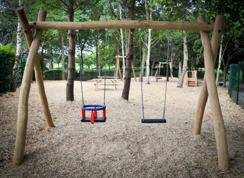 a swing set in a park with a playground at Mount Wolseley Hotel Spa & Golf Resort in Tullow