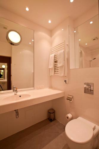 a bathroom with a sink and a toilet and a mirror at Amber SPA Boutique Hotel in Jūrmala