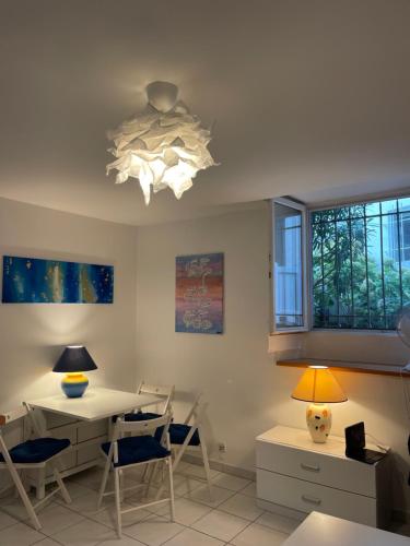 une salle à manger avec une table et des chaises et un plafonnier dans l'établissement Appartement BIARRITZ, à Biarritz
