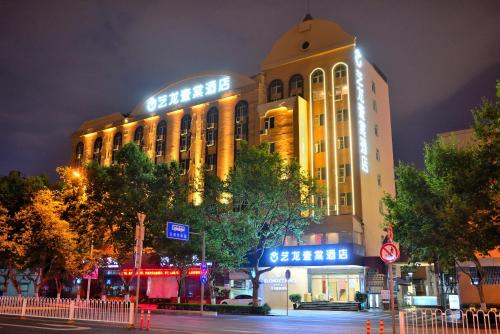 a large building with lights on it at night at Yilong Yitang Hotel Kunming Railway Station Joy City Center in Kunming