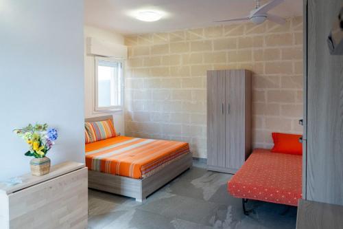 a small room with a bed and a bench at Casa Vacanza Mario 1A a 180 mt dal mare di Punta Prosciutto in Punta Prosciutto