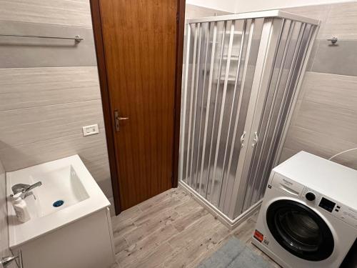 un bagno con lavatrice e lavandino di Casa felicità Sciacca a Sciacca