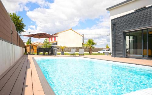 une piscine dans l'arrière-cour d'une maison dans l'établissement La Rochette - Magnifique Villa calme et paisible, à Le Loroux-Bottereau