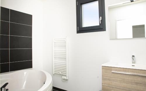 une salle de bain avec une baignoire blanche et un lavabo dans l'établissement La Rochette - Magnifique Villa calme et paisible, à Le Loroux-Bottereau