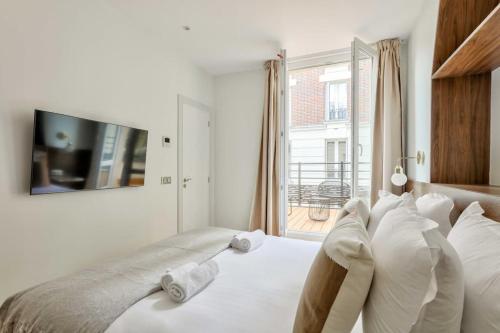 une chambre avec un grand lit blanc avec une fenêtre dans l'établissement Terrace Getaway - Le Marais - with AC, à Paris