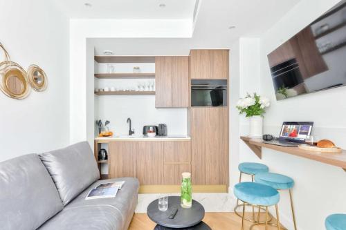 - un salon avec un canapé et deux tabourets bleus dans l'établissement Terrace Getaway - Le Marais - with AC, à Paris