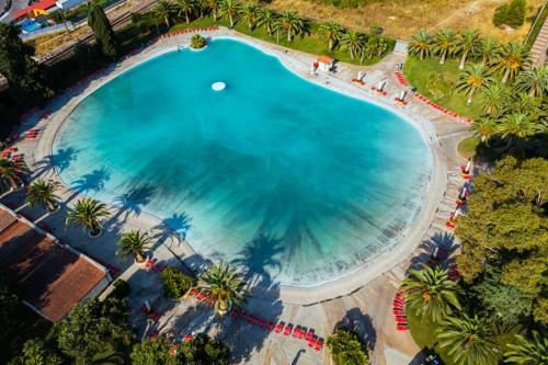 an overhead view of a large swimming pool with palm trees at Victoria Terme Hotel in Tivoli Terme