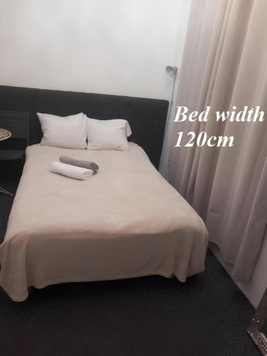 a bed with white sheets and pillows in a room at Studio "11"near Monaco in Beausoleil