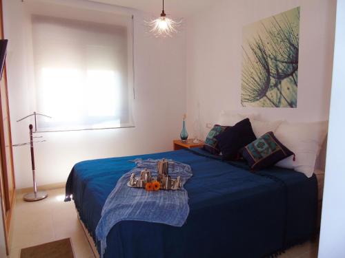 Un dormitorio con una cama azul con una bandeja de comida. en A&N Valle-Niza, en Vélez-Málaga