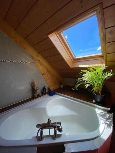 La salle de bains est pourvue d'une baignoire et d'une fenêtre. dans l'établissement Charmante maison en bois 8 pers, à Fontenu