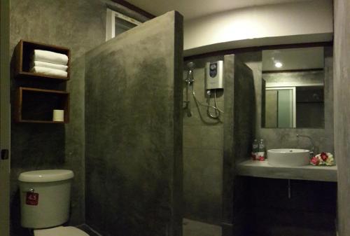 een badkamer met een douche, een toilet en een wastafel bij The Hip Resort @ Phi Phi in Phi Phi Don