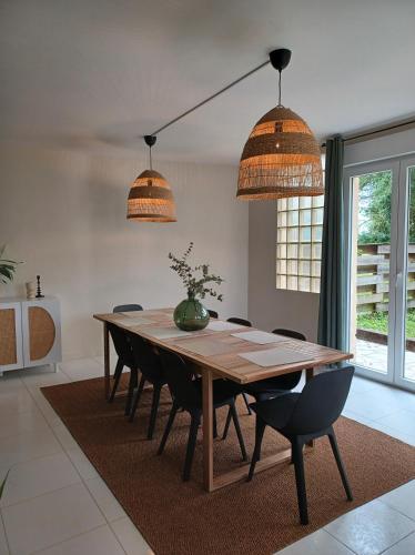 - une table à manger avec des chaises et des lampes suspendues dans l'établissement Gîte Château Touzinat - Saint-Emilion, à Saint-Émilion