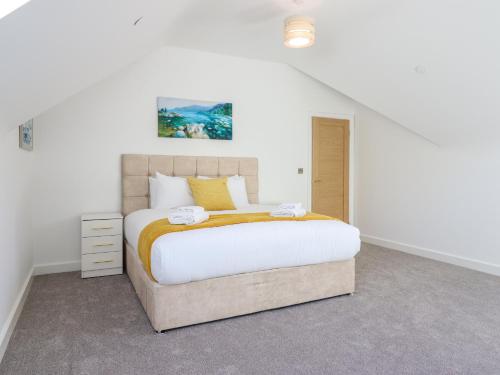 a bedroom with a large bed in a white room at Blackrock Gem in Porthmadog