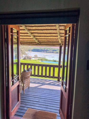 an open door to a porch with a view of the water at Tzamenkomst River Lodge in Colesberg