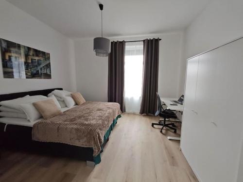 a bedroom with a bed and a desk in it at Pfalz Oase in Landau in der Pfalz