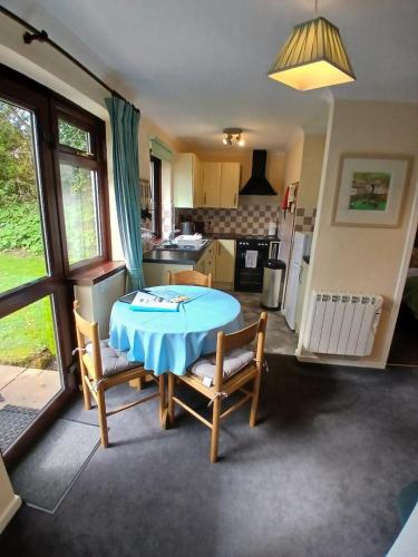 a kitchen with a table and two chairs and a table at Tolpedn Cottage in Gulval