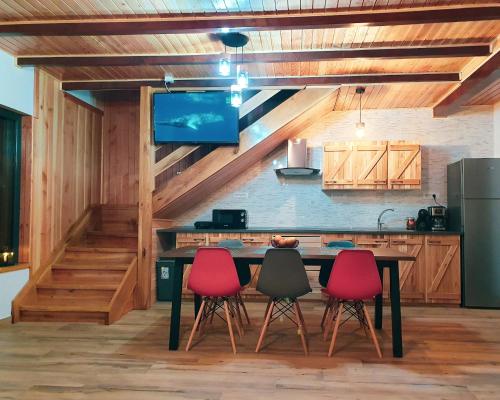 cocina con mesa con 4 sillas y TV en Gray River Resort, en Obârşia Lotrului