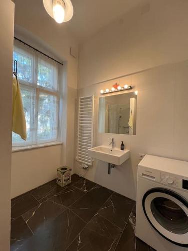 a bathroom with a sink and a washing machine at Beletage Johann Strauss in Klosterneuburg
