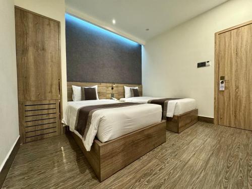 a bedroom with two beds and a blue light at LION 5 HOTEL in Can Tho