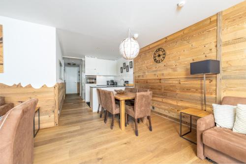 a kitchen and dining room with a wooden wall at Residence Bellevue - incl Summercard in Zell am See