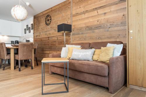 a living room with a brown couch and a table at Residence Bellevue - incl Summercard in Zell am See