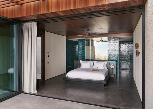 a bedroom with a bed and a glass wall at Maxx Royal Bodrum in Bodrum City