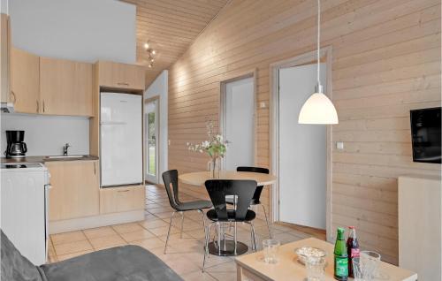 a kitchen and living room with a table and chairs at Lovely Home In Pandrup With Kitchen in Pandrup