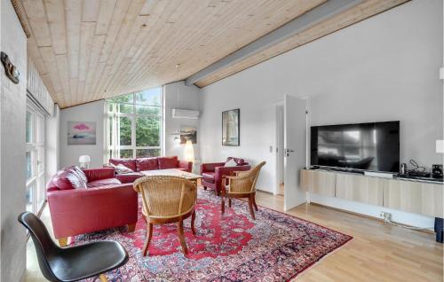 a living room with a red couch and a table at Beautiful Home In Vestervig With Sauna in Vestervig