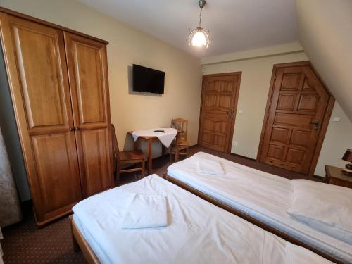 a hotel room with two beds and a table at Willa pod Smrekiem in Białka Tatrzanska