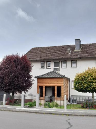 a large white house with a fence in front of it at Ferienwohnung am Fussweg zur Therme in Bad Rodach