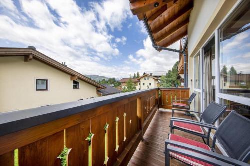 a balcony with two chairs and a wooden railing at Königsblick Top 6 in Königsleiten