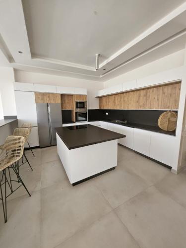 a kitchen with white cabinets and a black counter top at Domaine de Kali, villa 2 au calme, piscine privée in Marrakech