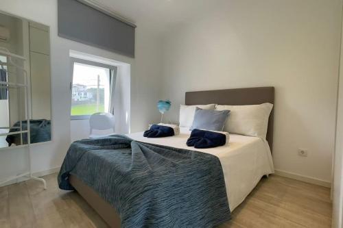 a bedroom with a large bed and a window at Casa do Mar North in Ponta Delgada