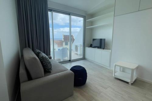a living room with a couch and a large window at Casa do Mar North in Ponta Delgada