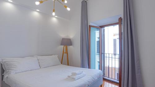 een slaapkamer met een bed en een groot raam bij EasyTopStay - Piazza Navona Elegant Apartment in Rome