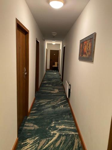 a corridor of a hotel room with a carpeted hallway at Hôtel Le Saint Amand in Saint-Amand-Montrond