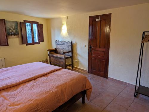 een slaapkamer met een bed en een stoel erin bij Casa Burga in Perelló