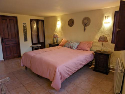 een slaapkamer met een groot bed met een roze deken bij Casa Burga in Perelló
