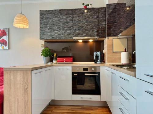 a kitchen with white cabinets and a counter top at Sunny & Comfort Apartment next to Tech Park for 4 Guests in Sofia
