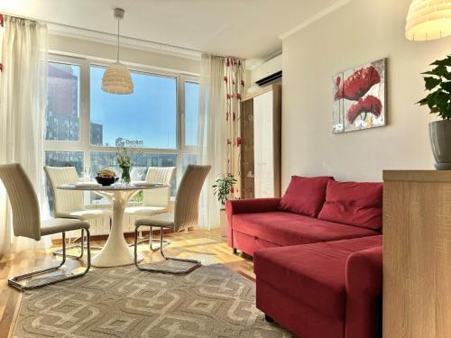 a living room with a red couch and a table at Sunny & Comfort Apartment next to Tech Park for 4 Guests in Sofia