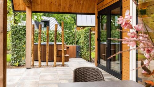 an outdoor patio with a table and chairs at Bosvilla with Hottub & Sauna | 8 persons in Wekerom