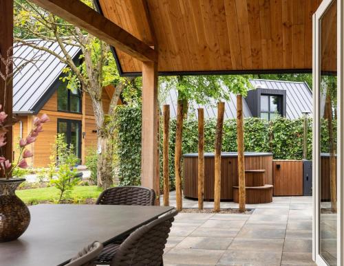an outdoor patio with a table and chairs at Bosvilla with Hottub | 6 persons in Wekerom