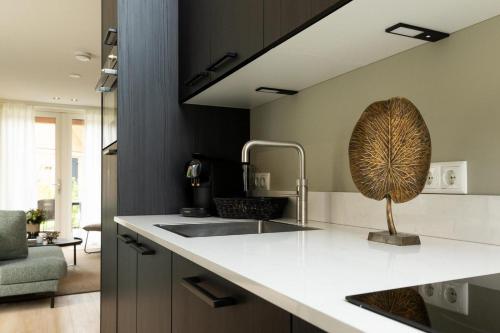 a kitchen with a sink and a faucet at Bos Villa met Hottub | 6 personen - Resort Valley in Wekerom