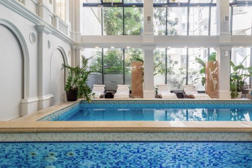 a pool in a building with a large room with a swimming pool at Queen's Court Hotel & Residence in Budapest